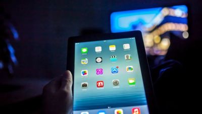 A person using an iPad and watching TV (Getty Images) 